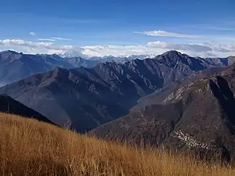 Val Grande, Pizzo Proman (la montaña más alta a la derecha), Cicogna (el pueblo pequeño en la esquina inferior derecha) y el Monte Rosa (izquierda, cubierto por nubes), vistos desde Pizzo Pernice
