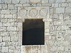 Ventana adintelada en la torre del homenaje. Sobre ella los escudos del conde de Benavente.