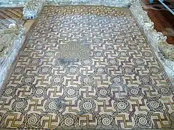 Mosaico en que puede apreciarse la mancha dejada por una hoguera en los tiempos de abandono de la villa.