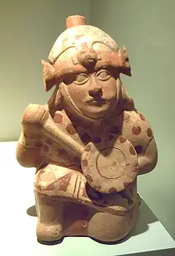 Guerrero moche genuflexo con armas.