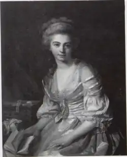 Retrato de Vestier realizado por su padre. La artista está sentada con un vestido blanco con corpiño rosa, con un libro en su mano derecha. un vestido