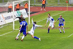 Aleksejs Soleičuks intenta bloquear un tiro de Vitalijus Kavaliauskas al arco del portero Jevgēņijs Sazanovs en el partido entre SK Liepājas Metalurgs y FC Tranzit.