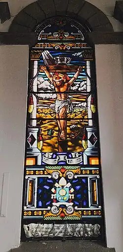 Vitral de la Crucifixión de Jesucristo con una heráldica y la frase: ''Cargado con nuestros pecados subió al leño para que muertos en pecado, vivamos para la justicia. Sus heridas nos han curado''