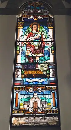 Vitral del Arcángel San Miguel con la segunda versión del Santuario (1717-1787) y la frase: ''San Miguel Arcángel, tercer patrono del Santuario. Defiéndenos del mal''