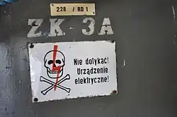 Cartel de calavera y huesos cruzados montado en una caja de electricidad en Polonia