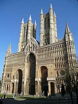 La fachada occidental de la catedral de Lincoln, una vasta pantalla rematada lateralmente con torretas similares a contrafuertes