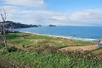 Vista general del campo de golf de Zarauz con la playa, el mar y el «ratón» de Guetaria al fondo