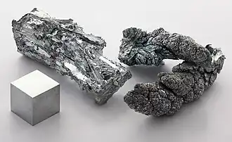 Fragmentos de zinc y un cubo de 1 cm3