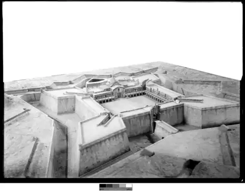 alt=Ciudadela de Montevideo : Foso con puente levadizo y puerta exterior (primer plano). Plaza de armas rodeada por columnas, (centro) luego transformada en mercado.